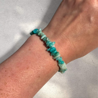 Turquoise coloured Russian amazonite crystal chip bracelet on a woman's wrist against a neutral sunlit background