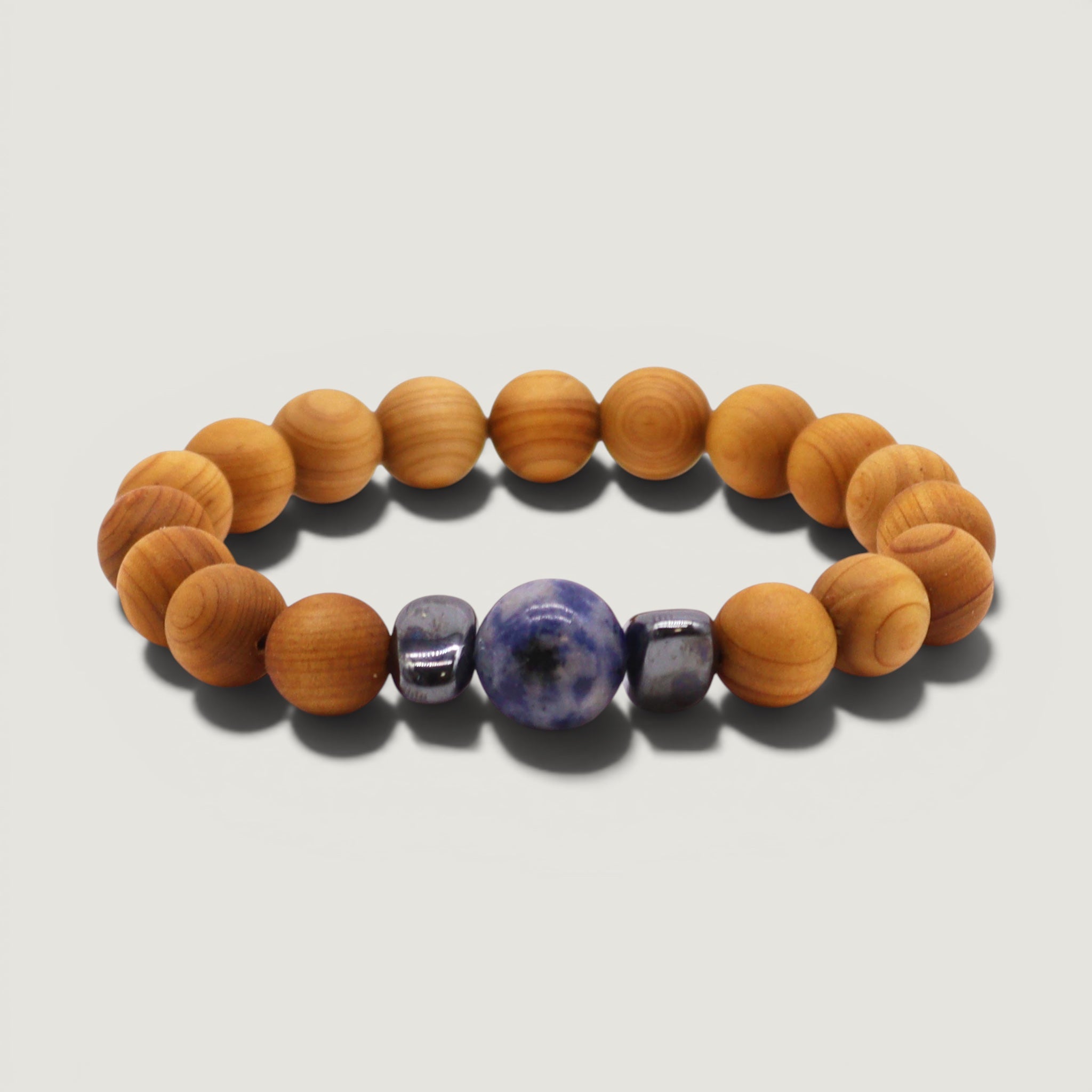Sodalite crystal Bracelet with cedarwood beads and hematite on a light grey background