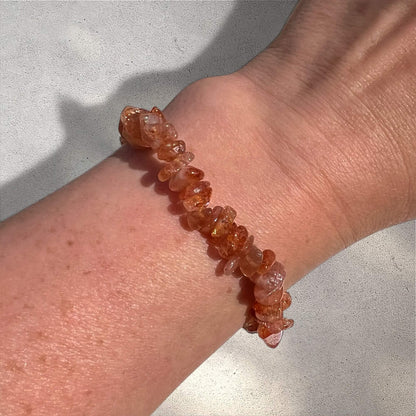 Close-up of a wrist wearing an Orange high grade sunstone crystal chip bracelet with sparkle