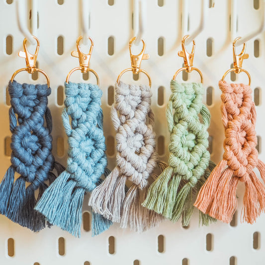 Five multi-coloured helix design macrame keyring hung in a row on a pinboard