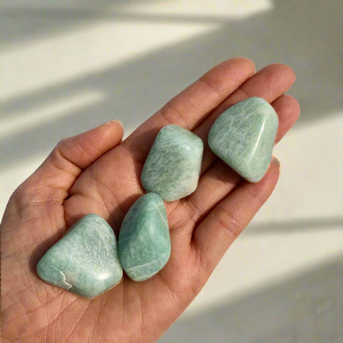 Extra large chunky turquoise coloured amazonite crystal tumble stones held in the palm of a hand