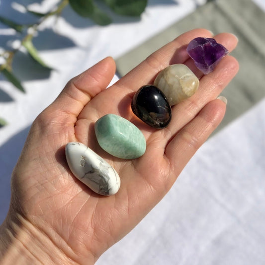 balance and tranquility healing crystal collection with white Howlite, green amazonite, smoky quartz, peach moonstone and purple amethyst tumble stones