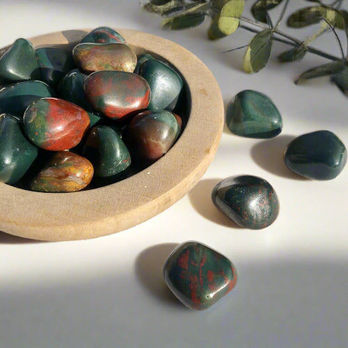 Wooden dish of red and green bloodstone crystal tumblestones