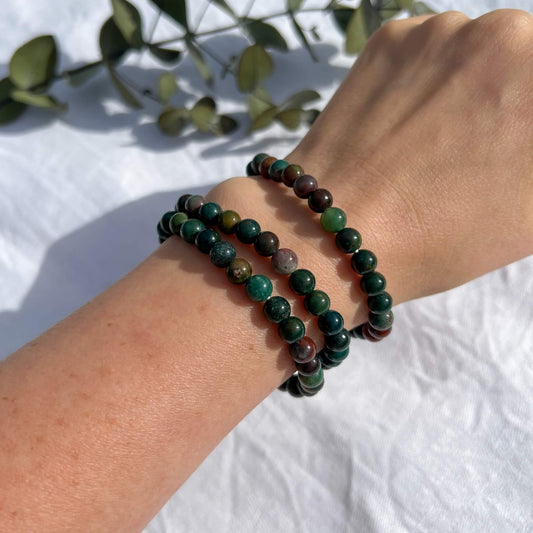 A lady's wrist with three green & red Bloodstone crystal bead bracelets
