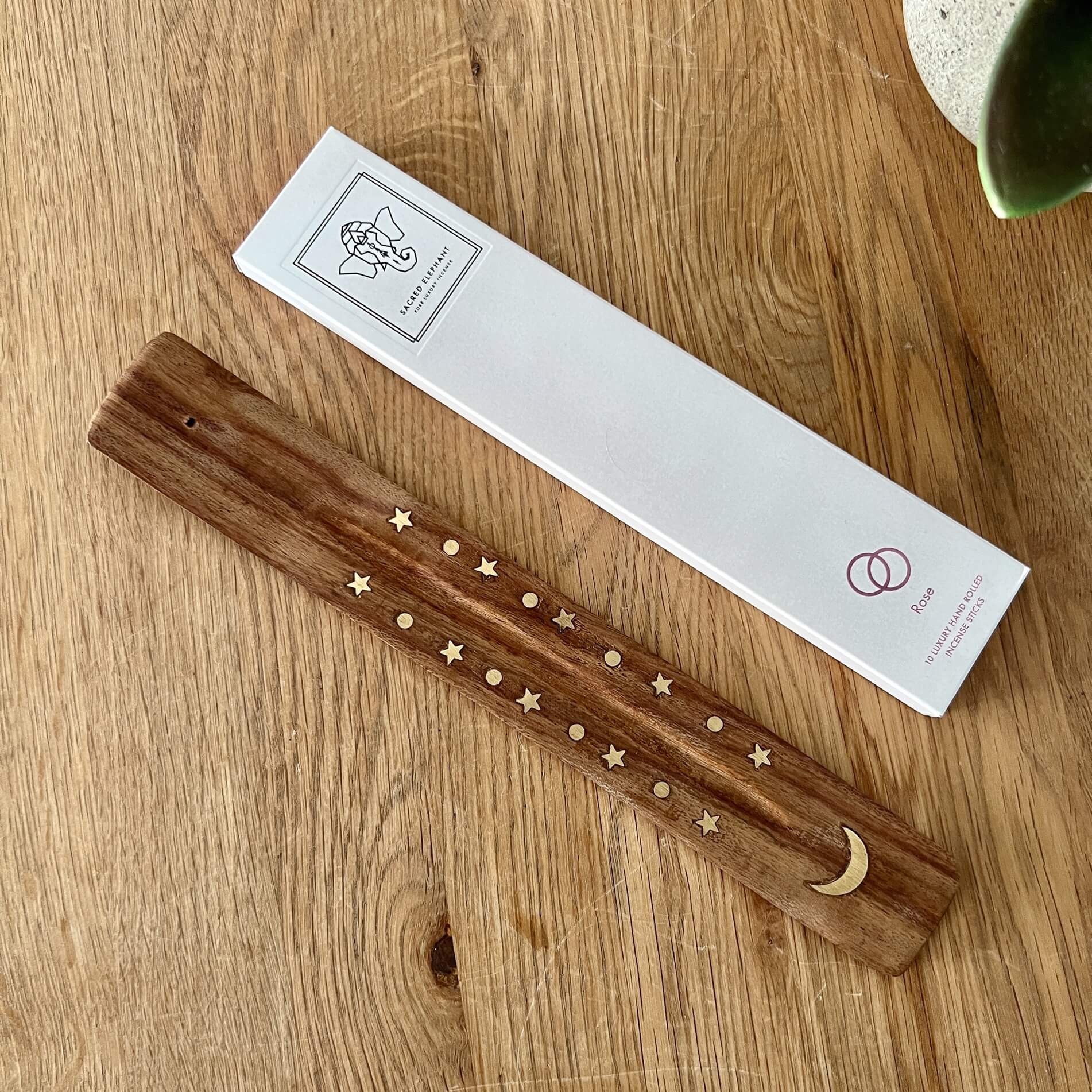 Mango wood ski incense holder with moon and star brass inlaid with a white packet of Sacred Elephant Rose Incense sticks