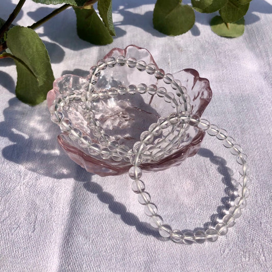 clear quartz crystal bead bracelets in a pink flower trinket dish