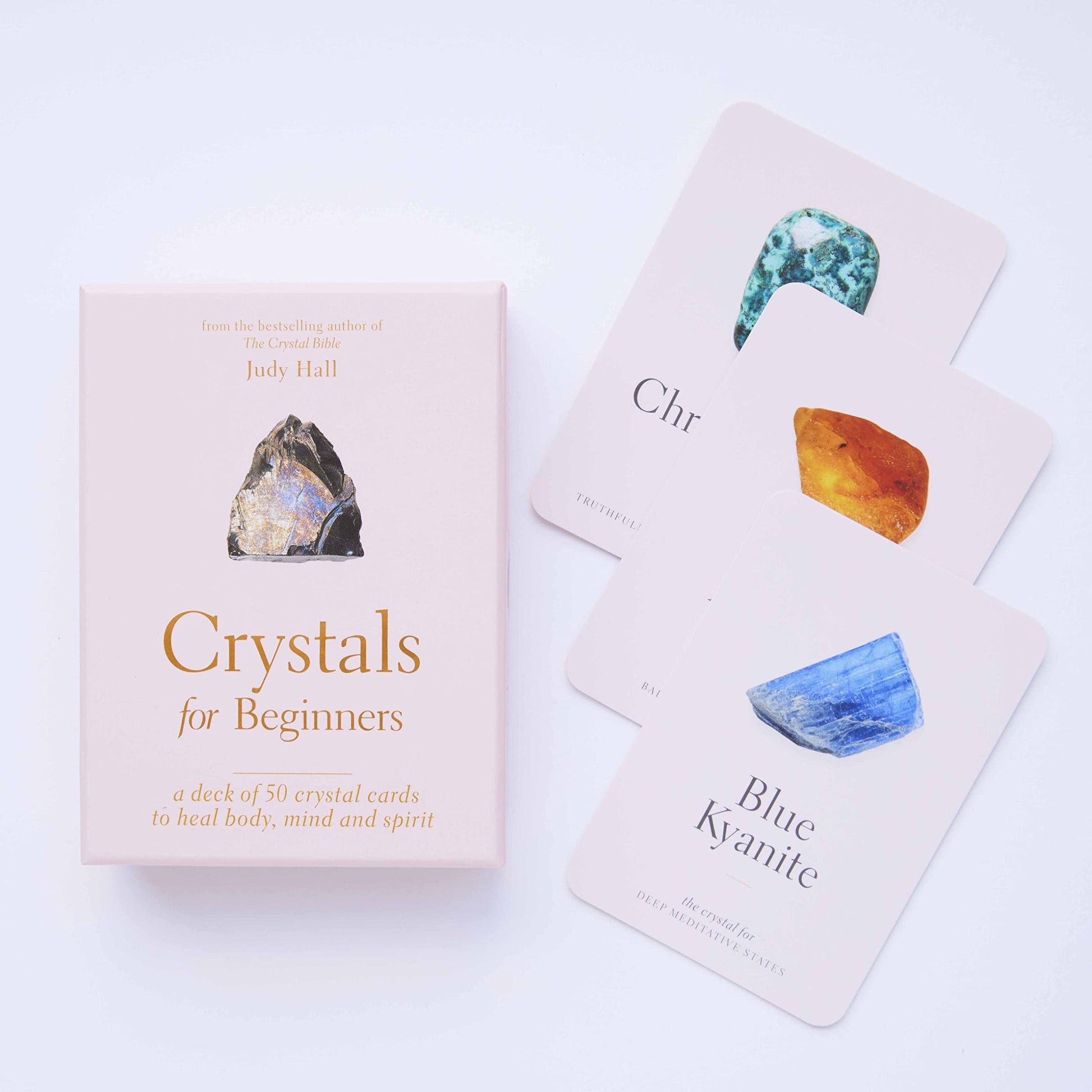 Pale pink Crystals for Beginners Card deck box by Judy hall with a spread of 3 crystal cards