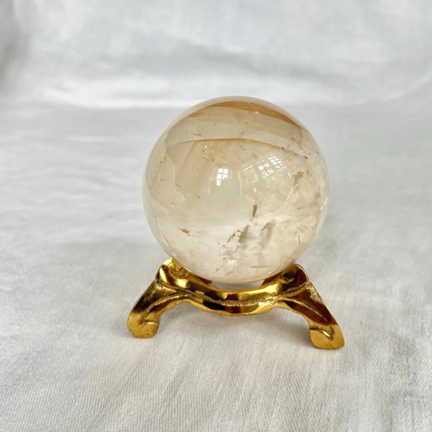 Vintage swirl style gold coloured crystal sphere holder with honey calcite sphere