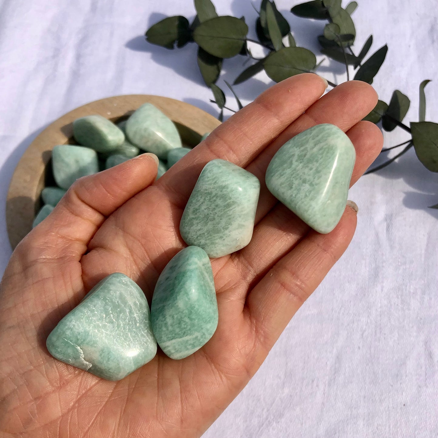 Extra large chunky turquoise coloured amazonite crystal tumble stones held in the palm of a hand