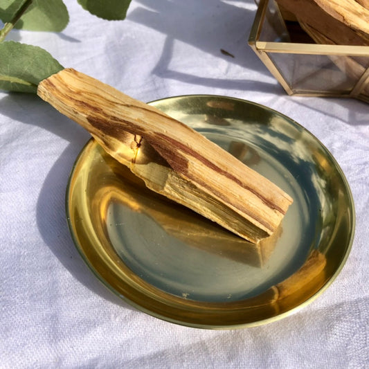 Palo Santo stick displayed in brass dish