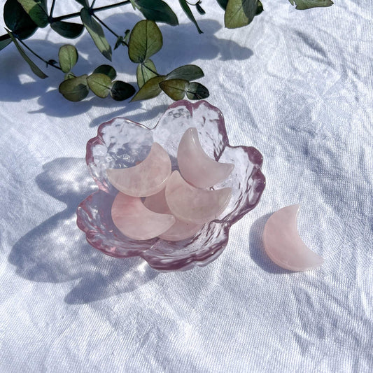 Glass trinket dish filled with small pale pink Rose Quartz crystal moons