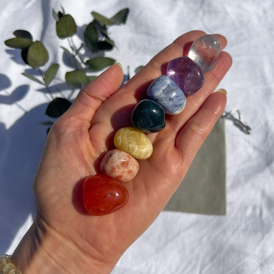 Seven crystals of each colour of the rainbow displayed in an outstretched hand