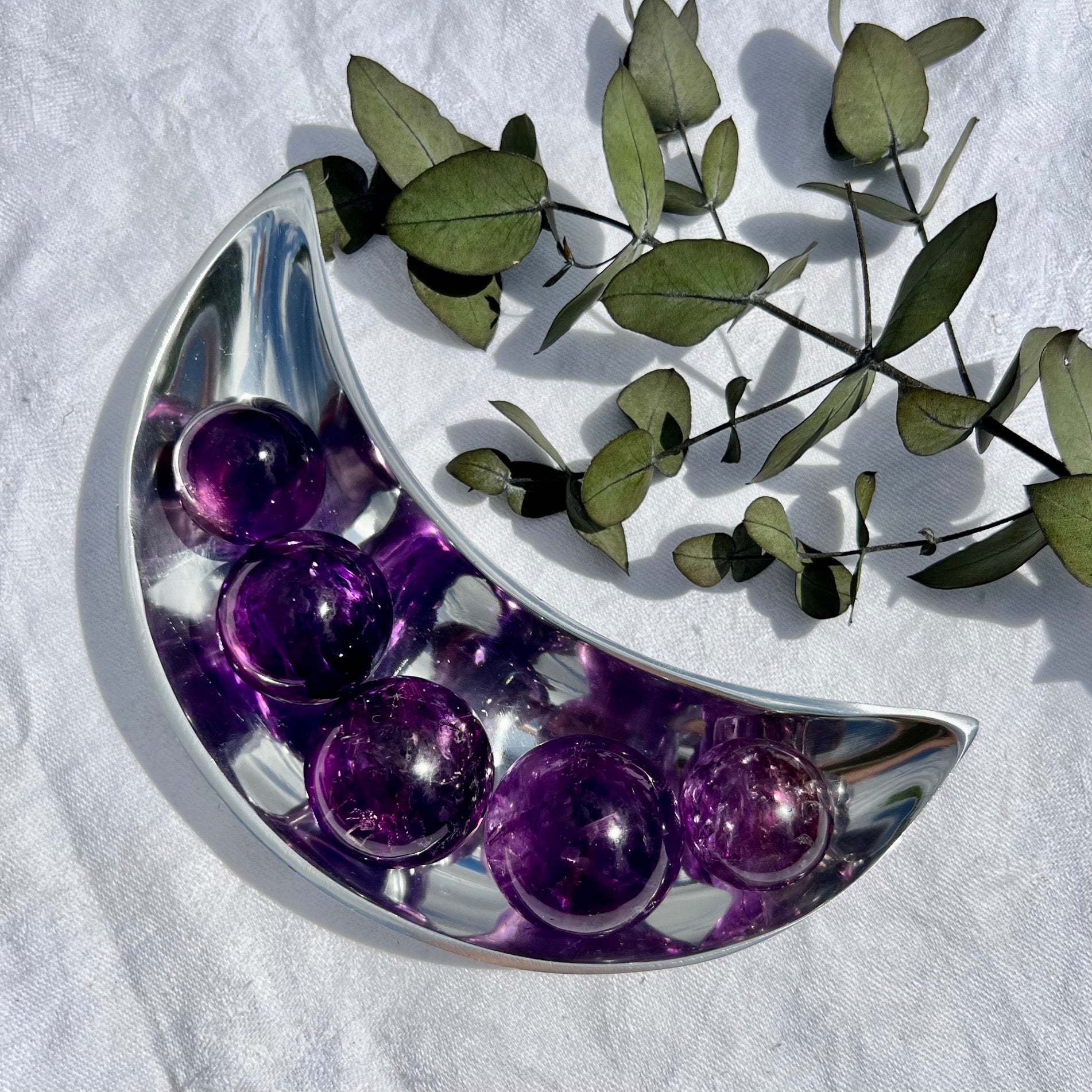 Silver moon bowl with five vivid purple amethyst spheres in it